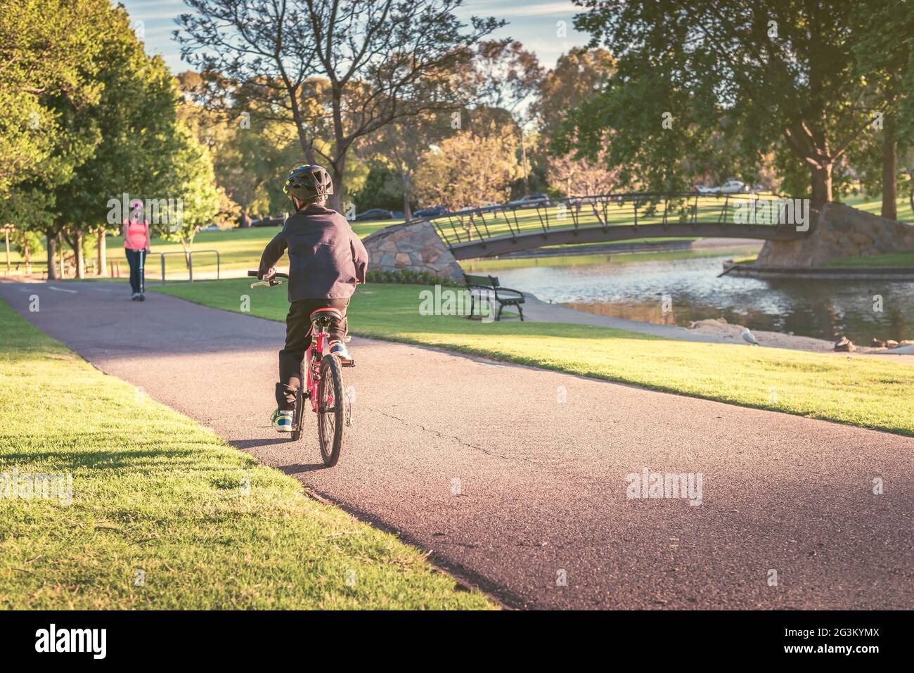 Australian boy riding his bicycle along the bike lane in Adelaide Park