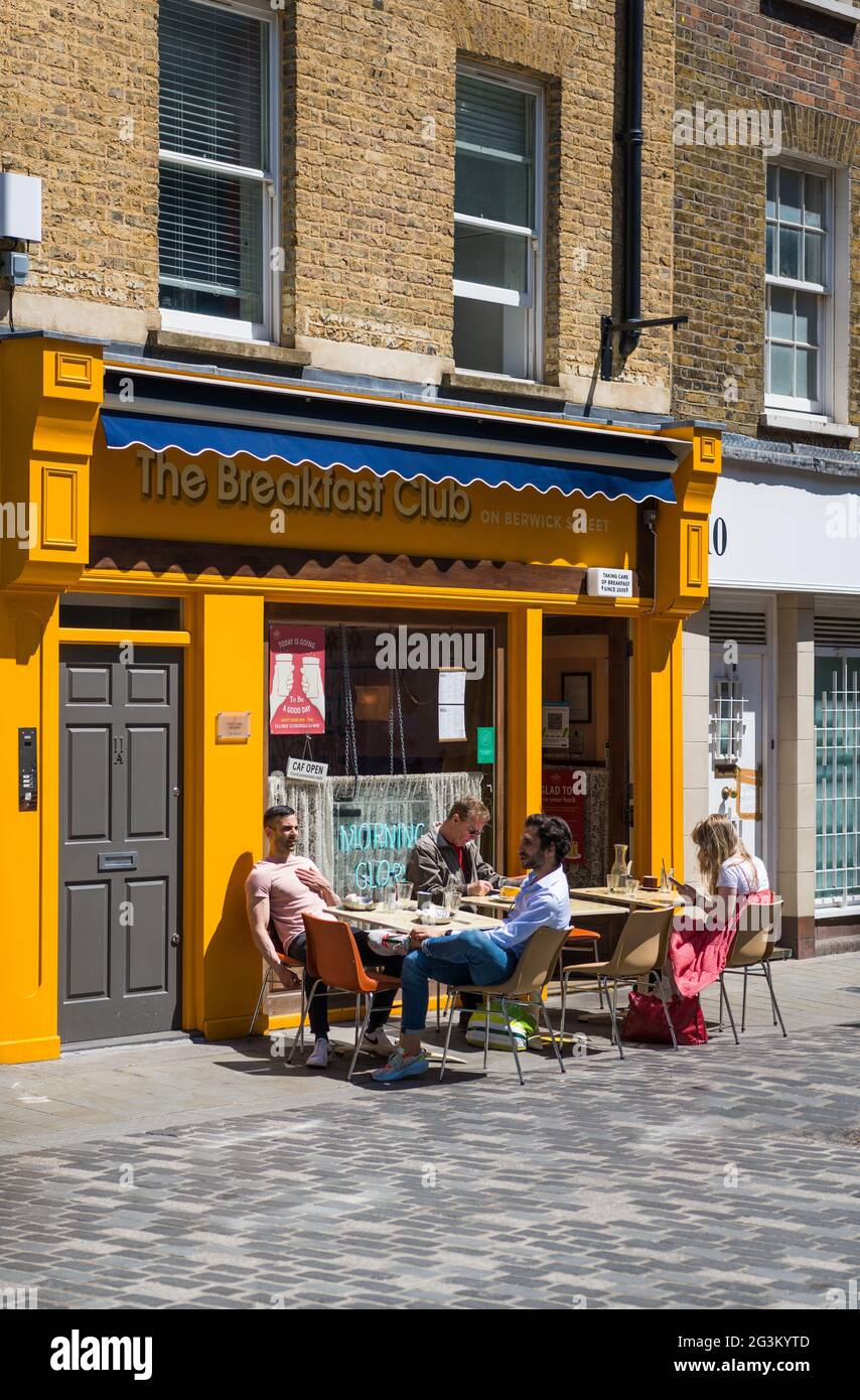 People seated at pavement tables outsideThe Breakfast Club in Berwick Street, Soho, London, England, UK Stock Photo