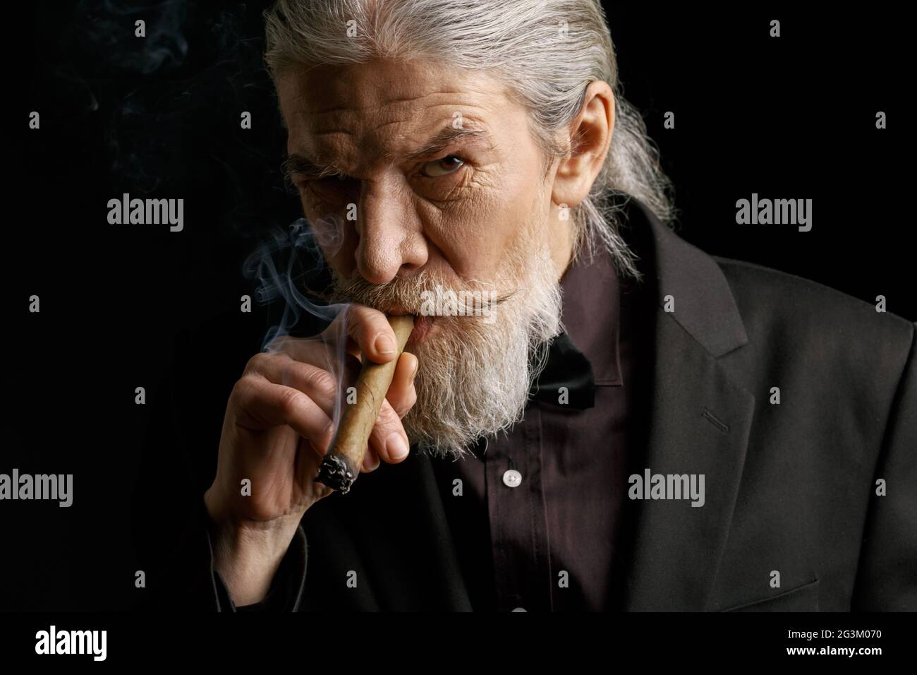 Stylish old man smoking cigar. Stock Photo