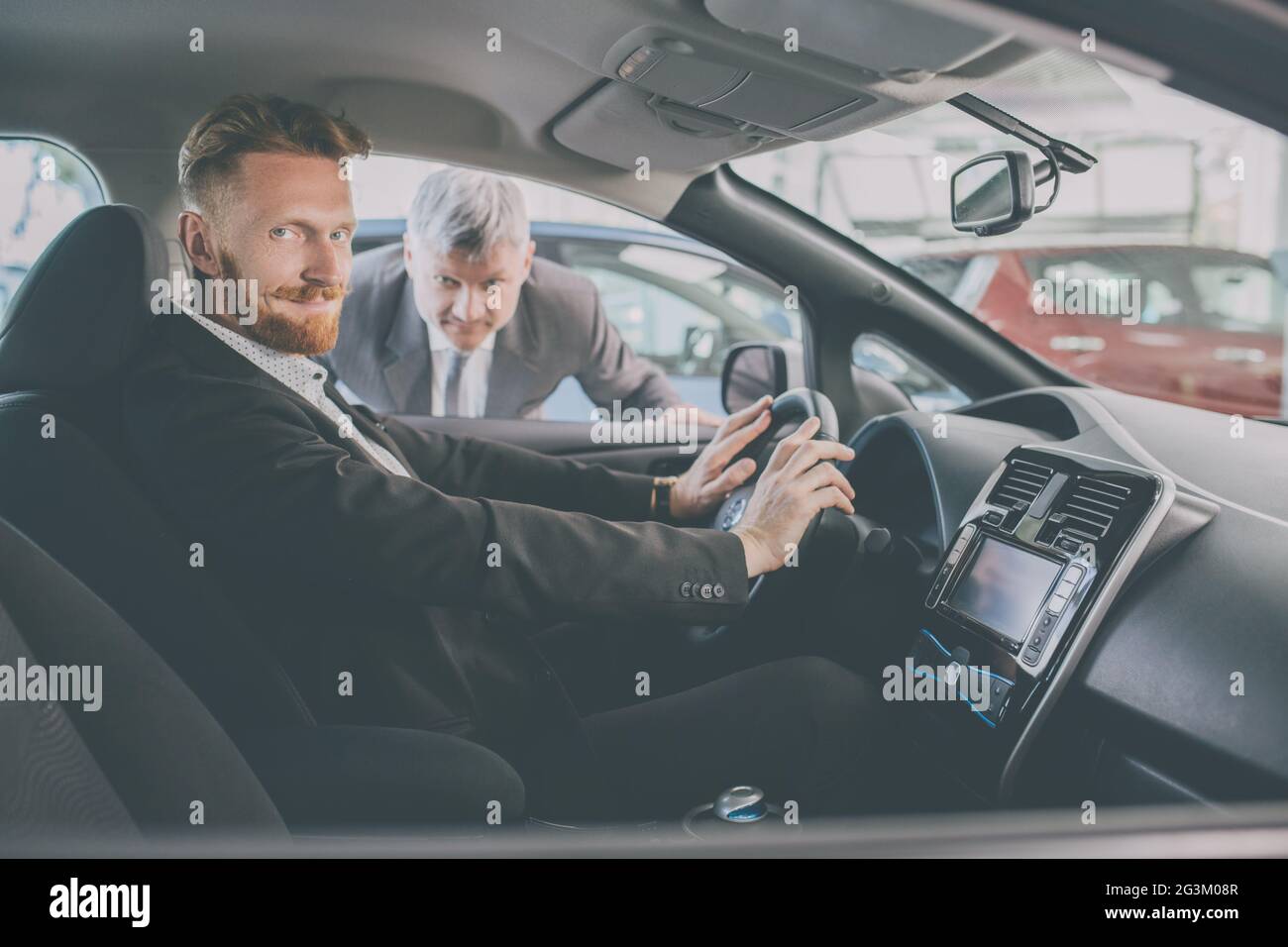 Vehicle dealer showing new car to a handsome man. Stock Photo