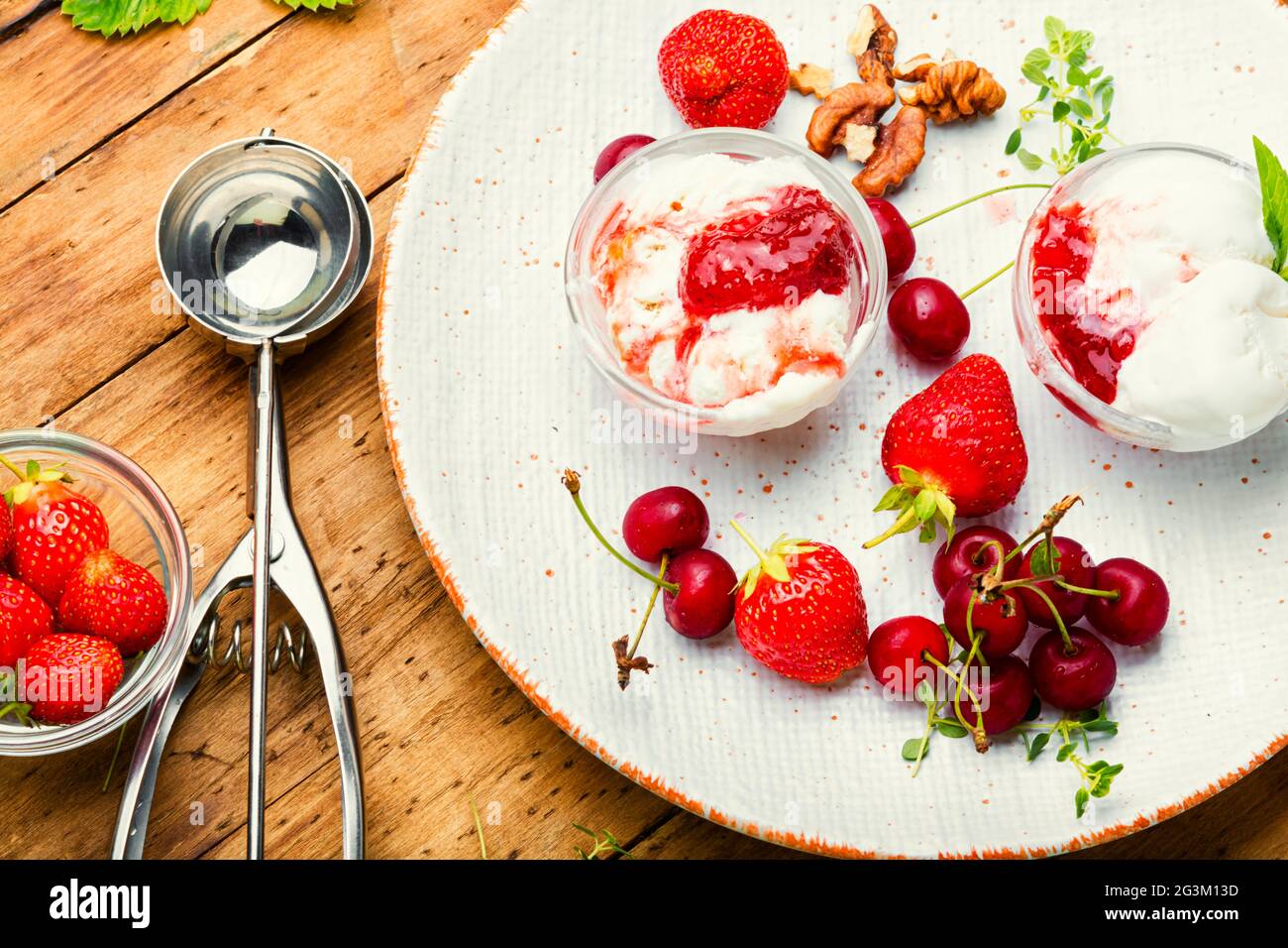 Summer dessert, ice cream with strawberries and cherries.Ice cream with berry jam on wooden table Stock Photo