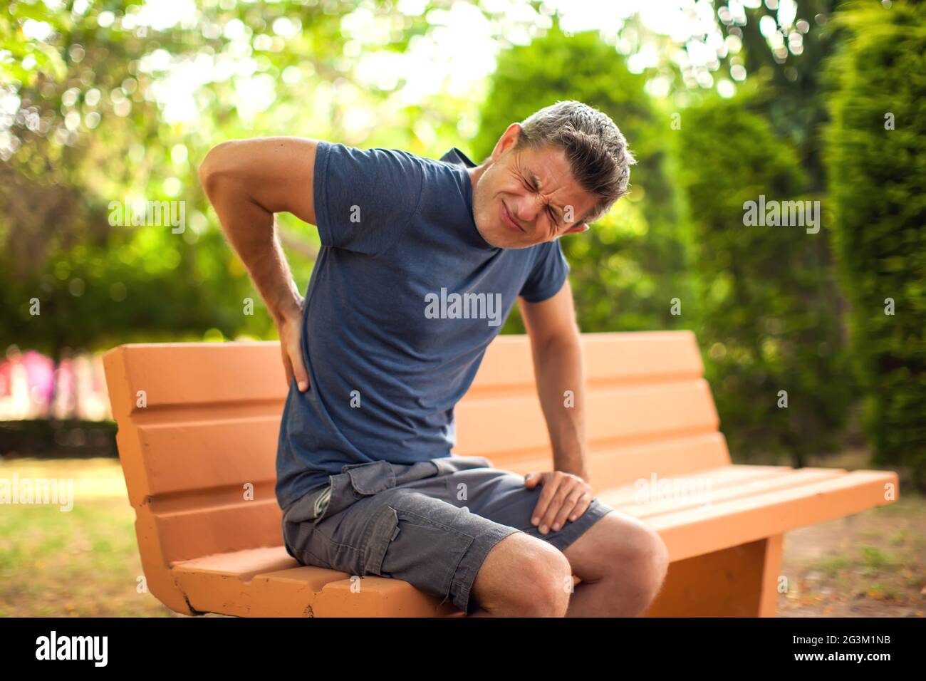 Man with back pain in the park. Healthcare and medicine concept Stock Photo