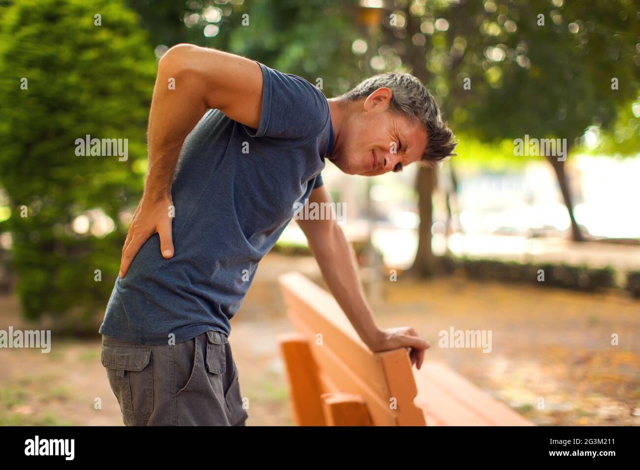 Man with back pain in the park. Healthcare and medicine concept Stock Photo