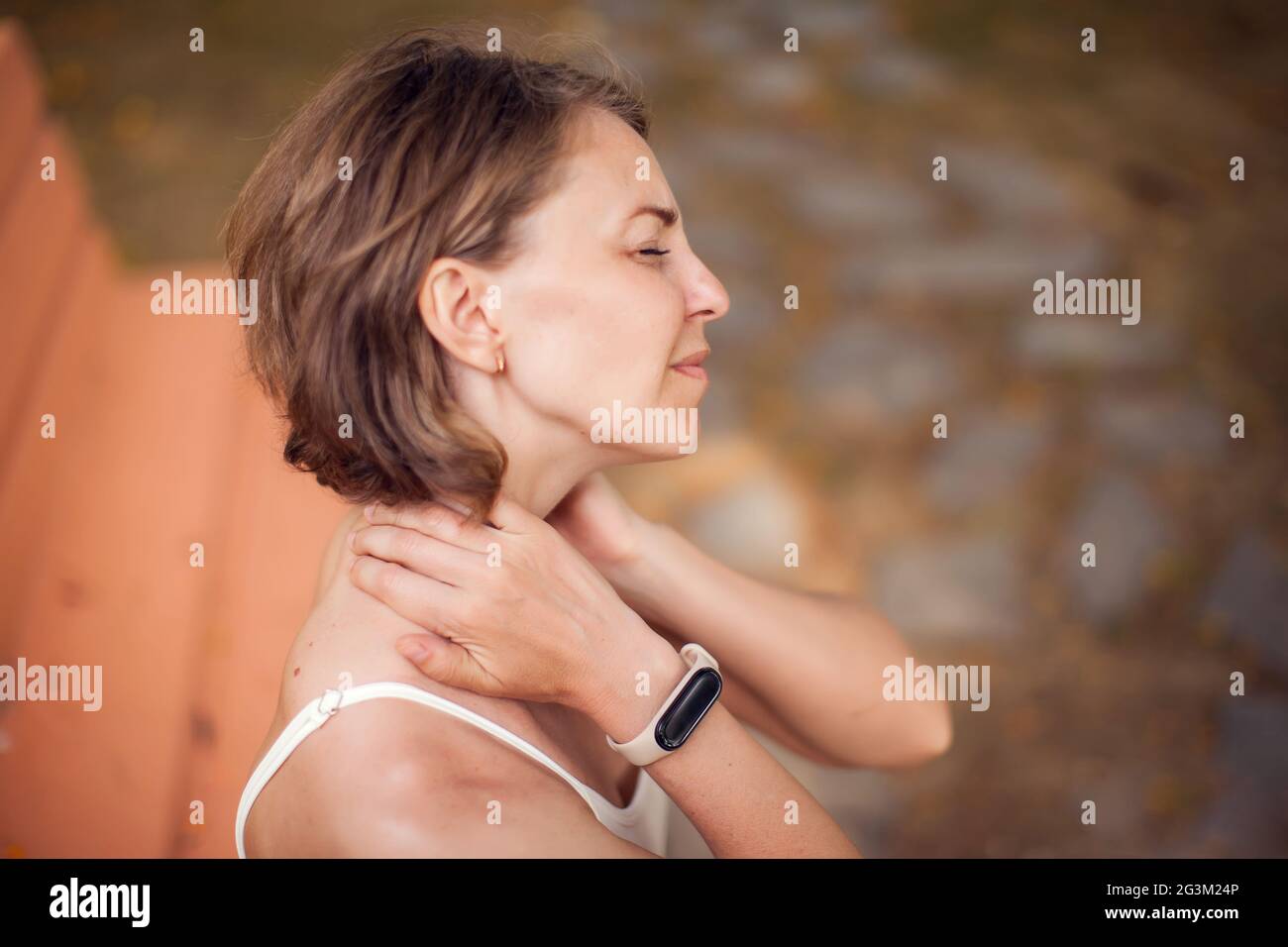 Woman with neck pain in the park. Healthcare and medicine concept Stock Photo