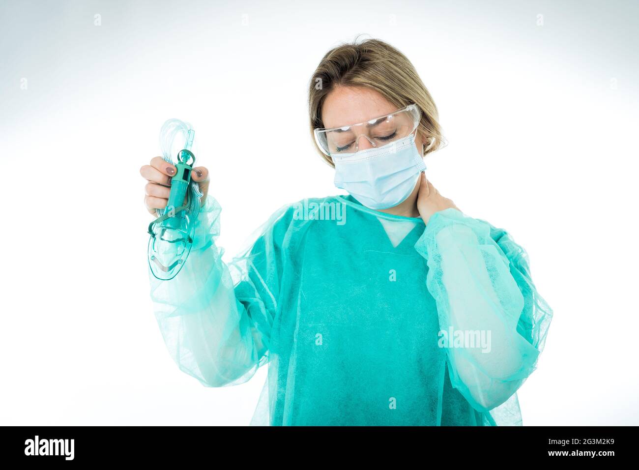 Portrait of exhausted Doctor in protective face mask holding non- invasive ventilator. Emotional stress of the front line health care workers, COVID-1 Stock Photo