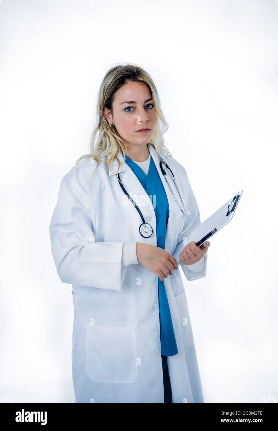 Overwhelmed female doctor or nurse wearing white coat over green scrub hospital uniform. frustrated and tired working at intensive care unit. Emotiona Stock Photo