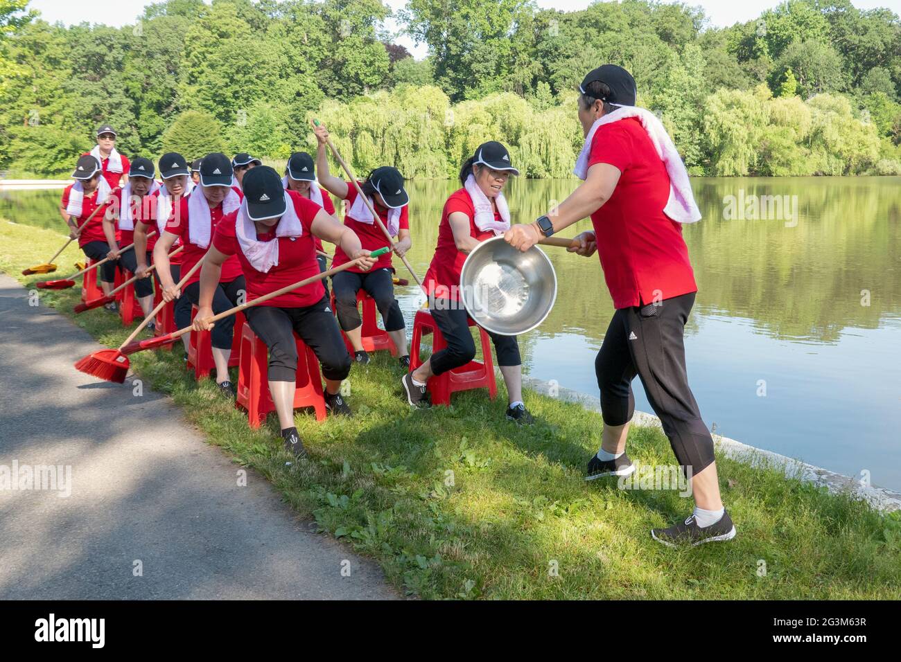 Middle age Chinese American dancer performing artists rehearse a rowing routine at a park in Flushing, Queens, New York City Stock Photo