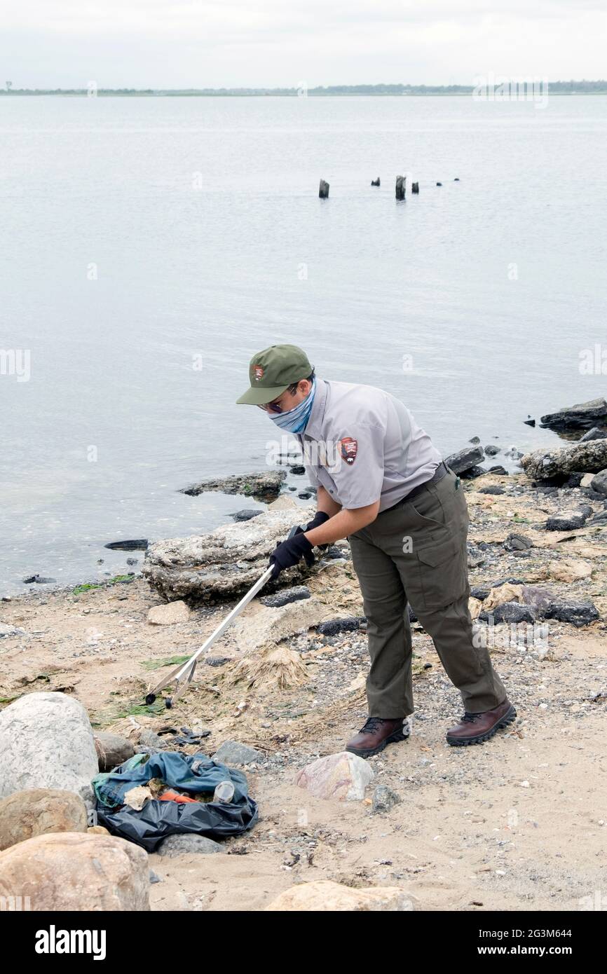 A National Park Service summer intern cleans the beach at Jamaica Bay in Queens as part of the 2021 Project Prithvi Beach Cleanup. Imn Queens, NYC. Stock Photo