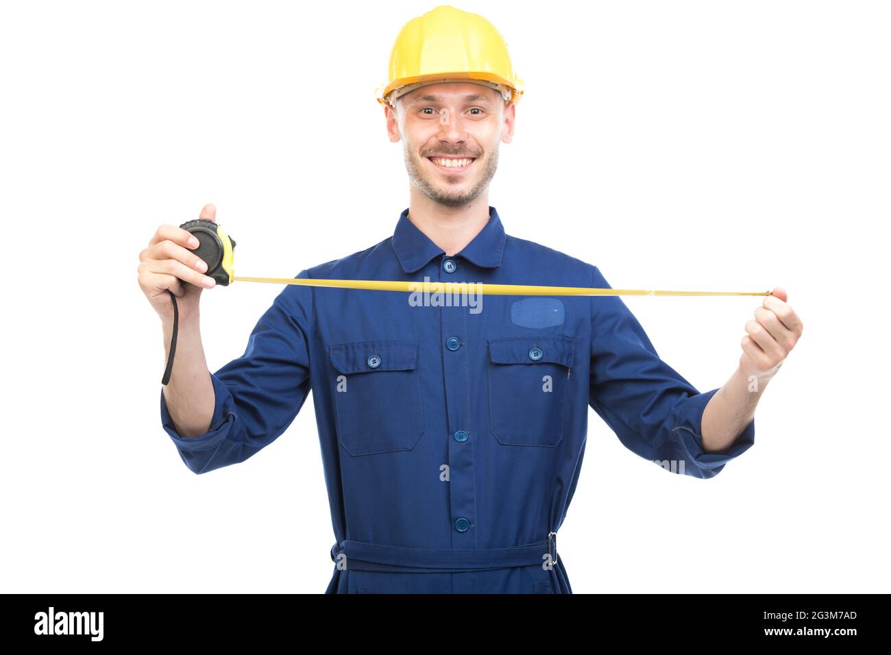 Horizontal portrait of successful handsome Caucasian construction engineer wearing uniform with hardhat measuring width or length of something Stock Photo