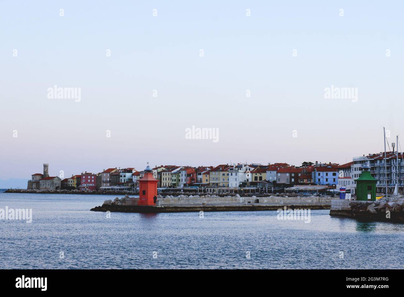 Red roofs of the historical center of old town Piran with beautiful lighthouse against the sunrise sky and Adriatic sea. Summer vacation to Slovenia. Stock Photo