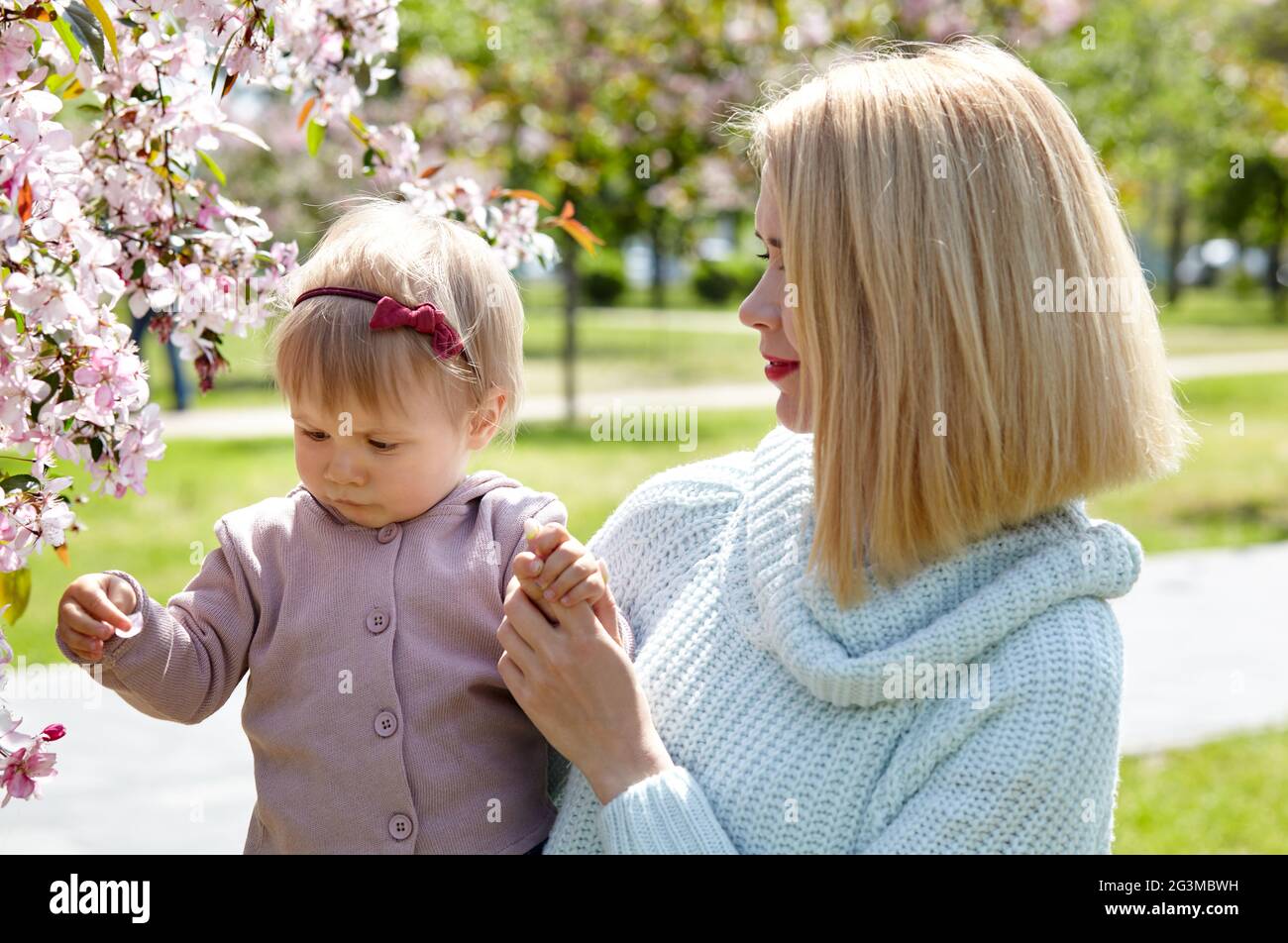 Mom and daughter on nature walk at spring park. Little girl and mother have a good time on weekend activity Stock Photo