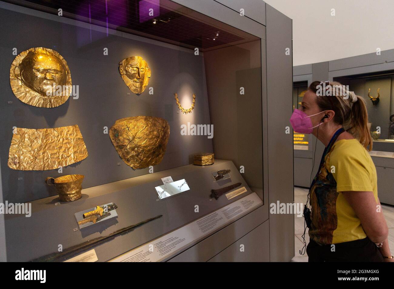 Athens, Greece. 7th June, 2021. A visiter views exhibits at the National Archaeological Museum in Athens, Greece, June 7, 2021. The imposing golden mask of Agamemnon welcomes visitors at the National Archaeological Museum here, standing out among other finds from the royal cemetery of the ancient city of Mycenae on the Peloponnese peninsula dating back to the 16th century BC. TO GO WITH 'Interview: Ancient Greek golden death-masks of Mycenae still engulfed in mystery, says archaeologist' Credit: Marios Lolos/Xinhua/Alamy Live News Stock Photo