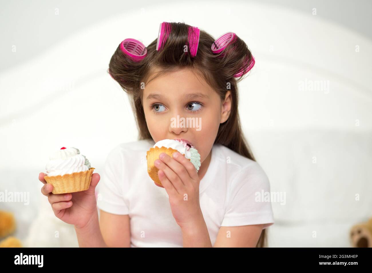Cute girl eating cupcake Stock Photo Alamy
