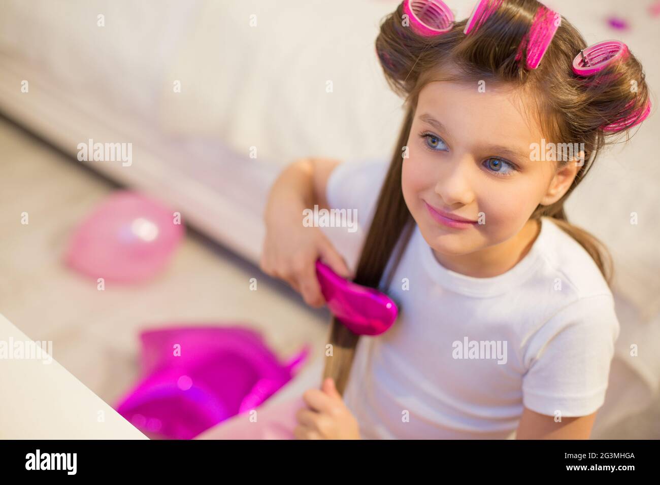 Cute girl brushing her hair. Stock Photo