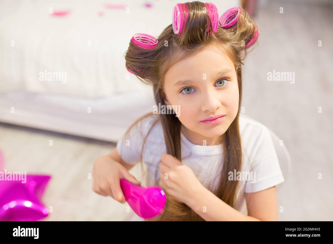 Cute girl brushing her hair. Stock Photo