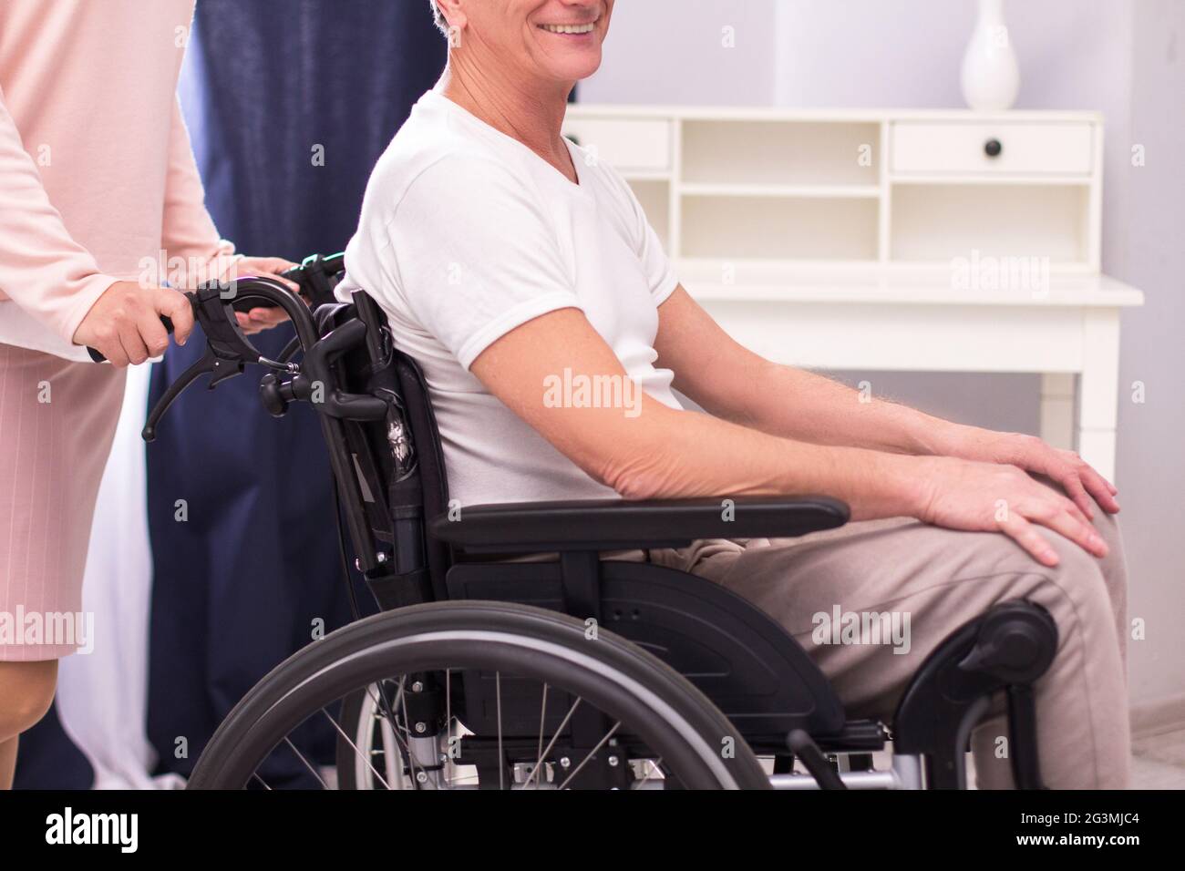 Nurse pushing wheelchair with man in it Stock Photo Alamy