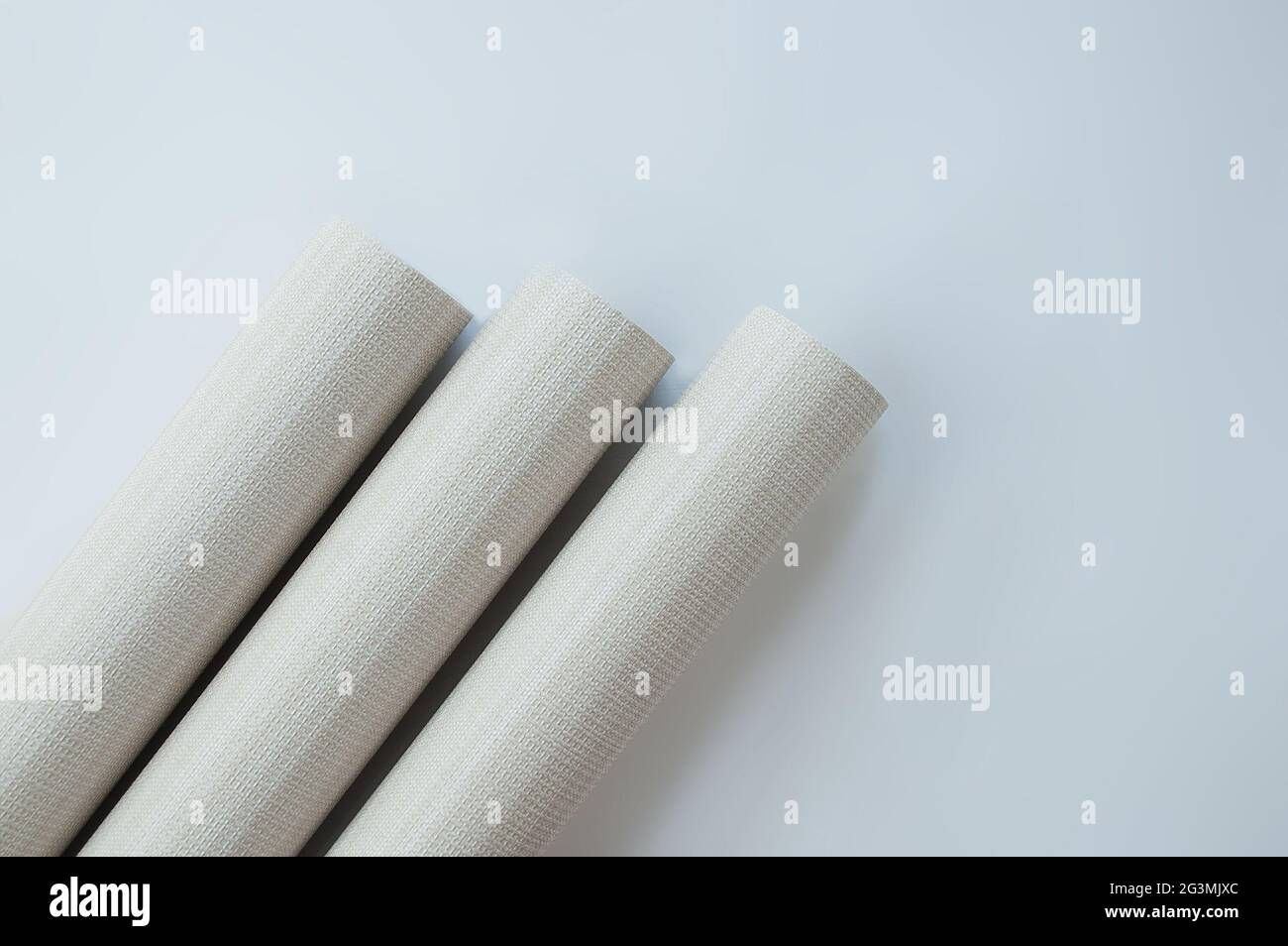 Three rolls of gray paper wallpaper for wall renovation. View from above. Stock Photo