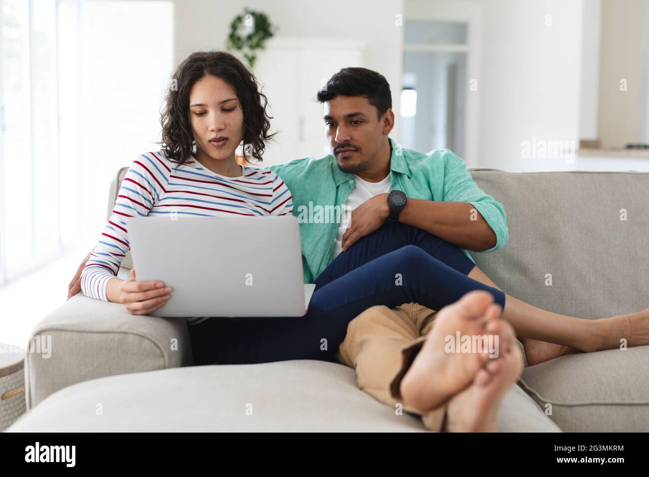 Hispanic couple relaxing on couch using laptop computer together Stock ...