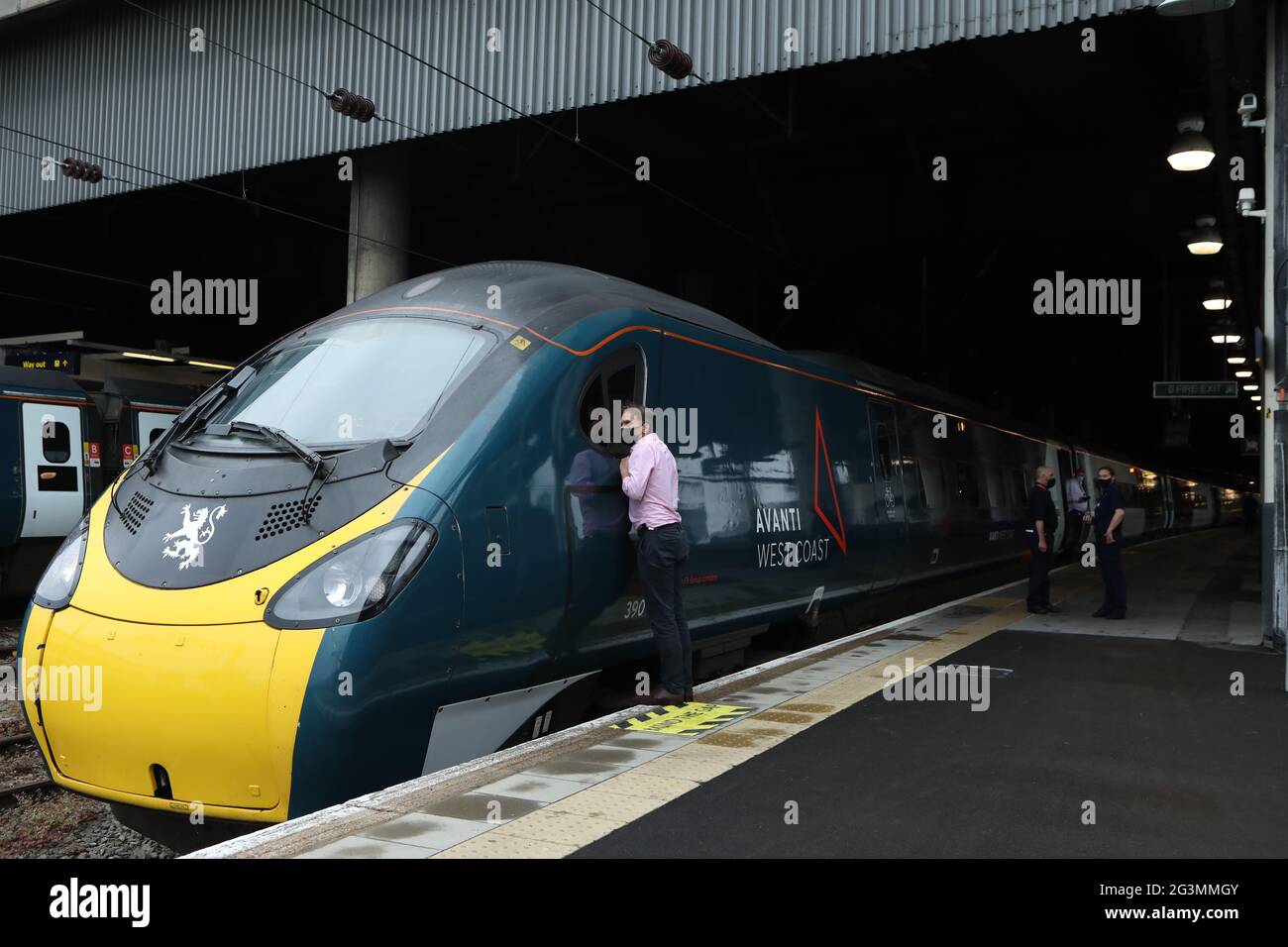 A man looks through the window of an Avanti West Coast Class 390 EMU train before it departs from London Euston for Glasgow Central Station on an attempt to break the 36-year-old record for the fastest train journey between London and Glasgow. The nine-carriage Pendolino train named Royal Scot needs to beat the previous record for the quickest train journey between the two cities of three hours, 52 minutes and 40 seconds, which was set by British Rail in December 1984 using a prototype Advanced Passenger Train. Picture date: Thursday June 17, 2021. Stock Photo