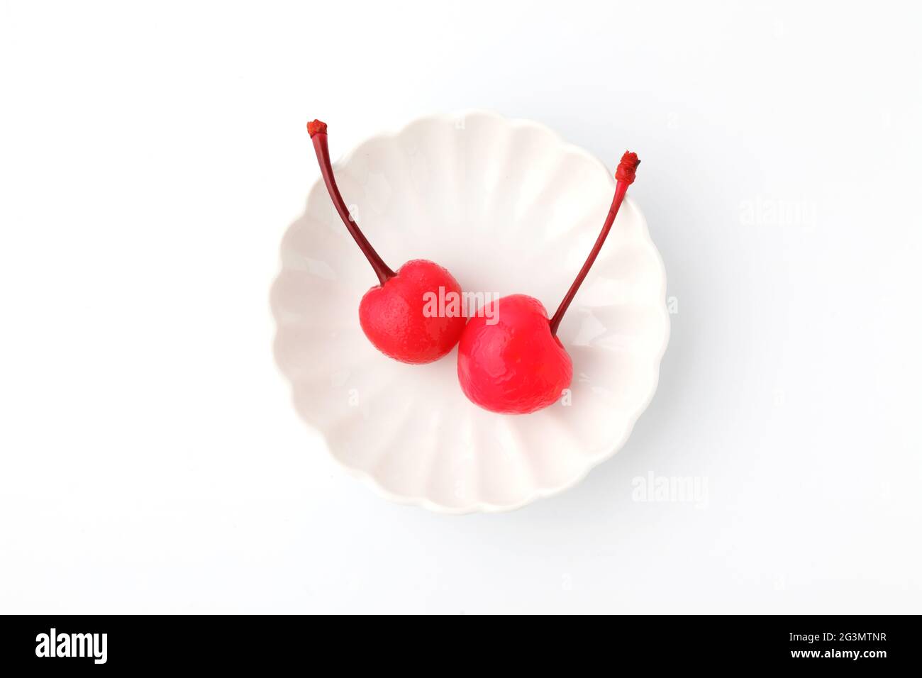 canned red cherries in syrup on plate isolated on white background
