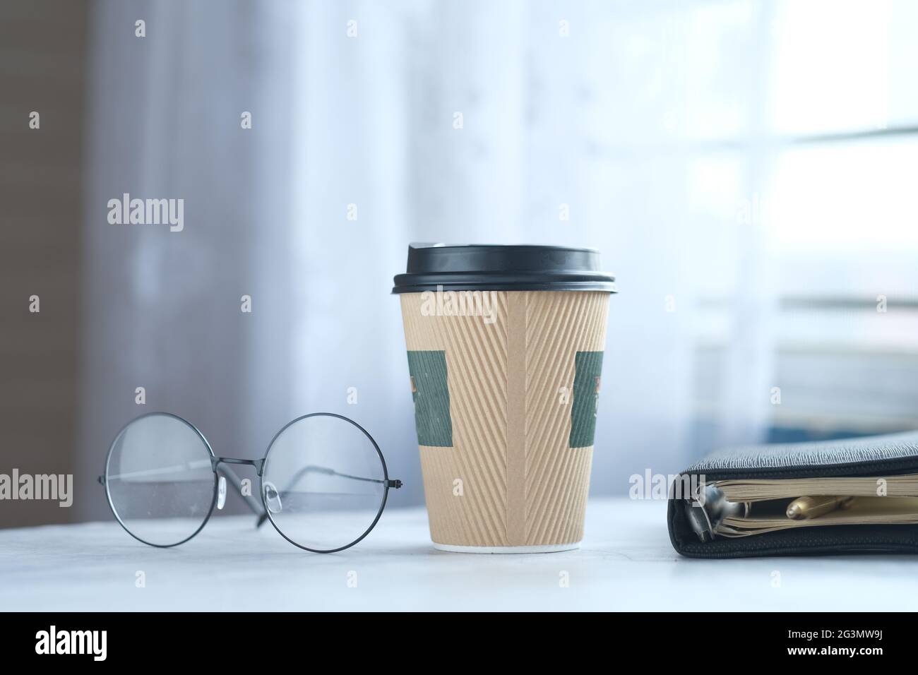 take away paper , eyeglass and notepad on table  Stock Photo
