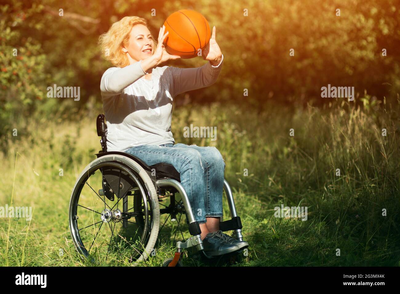 Wheelchair basketball player with ball on his lap Stock Photo