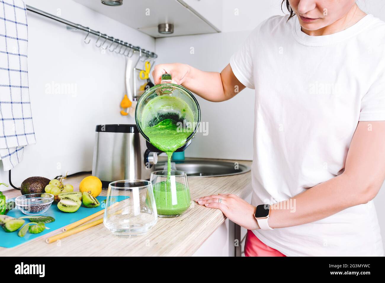 A woman is preparing a homemade detox juice or concentrated vitamin