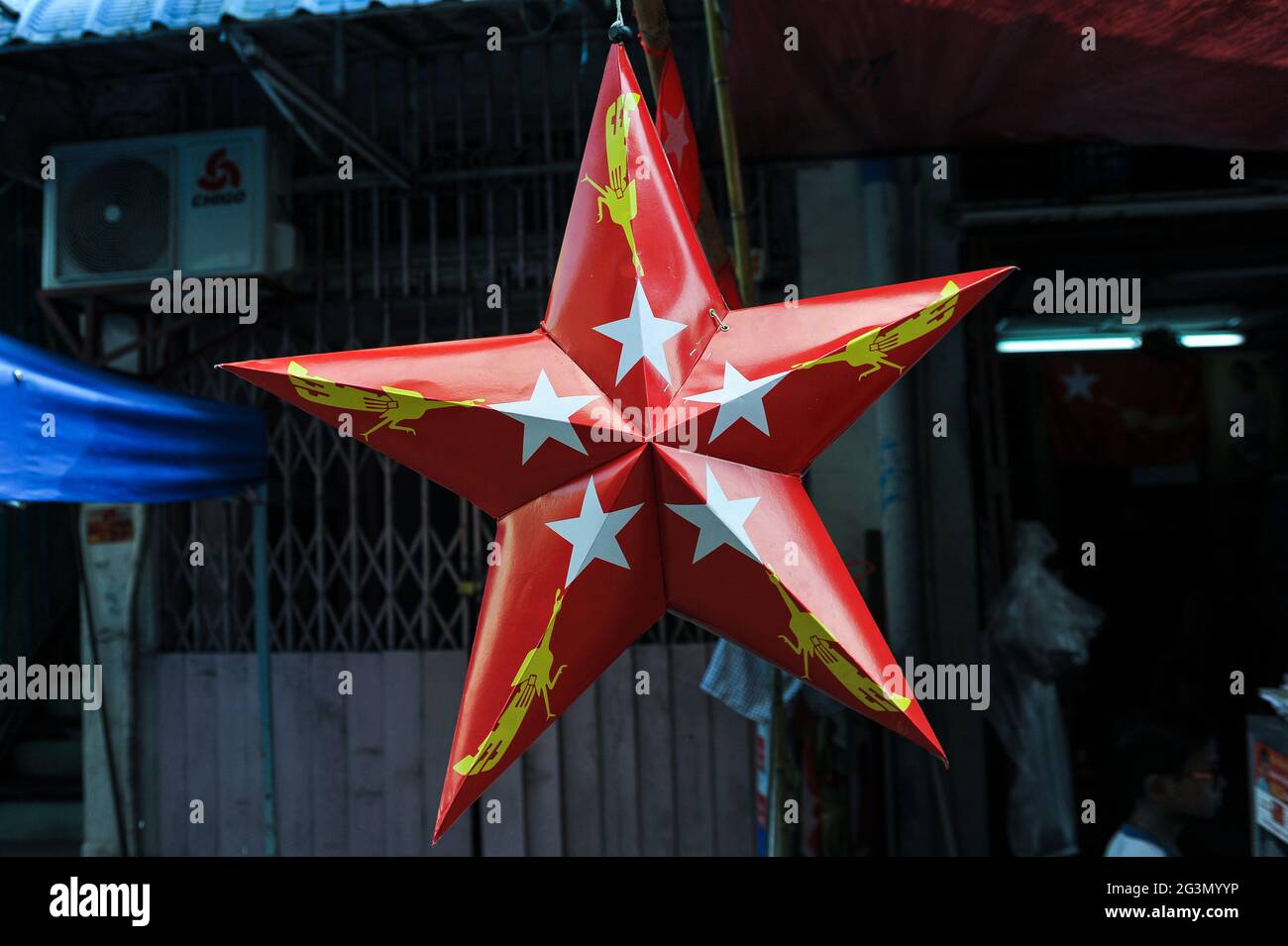 "31.10.2015, Yangon, , Myanmar - A red cardboard star with the logo of the NLD (National League for Democracy) party hangs from a street stall in the Stock Photo