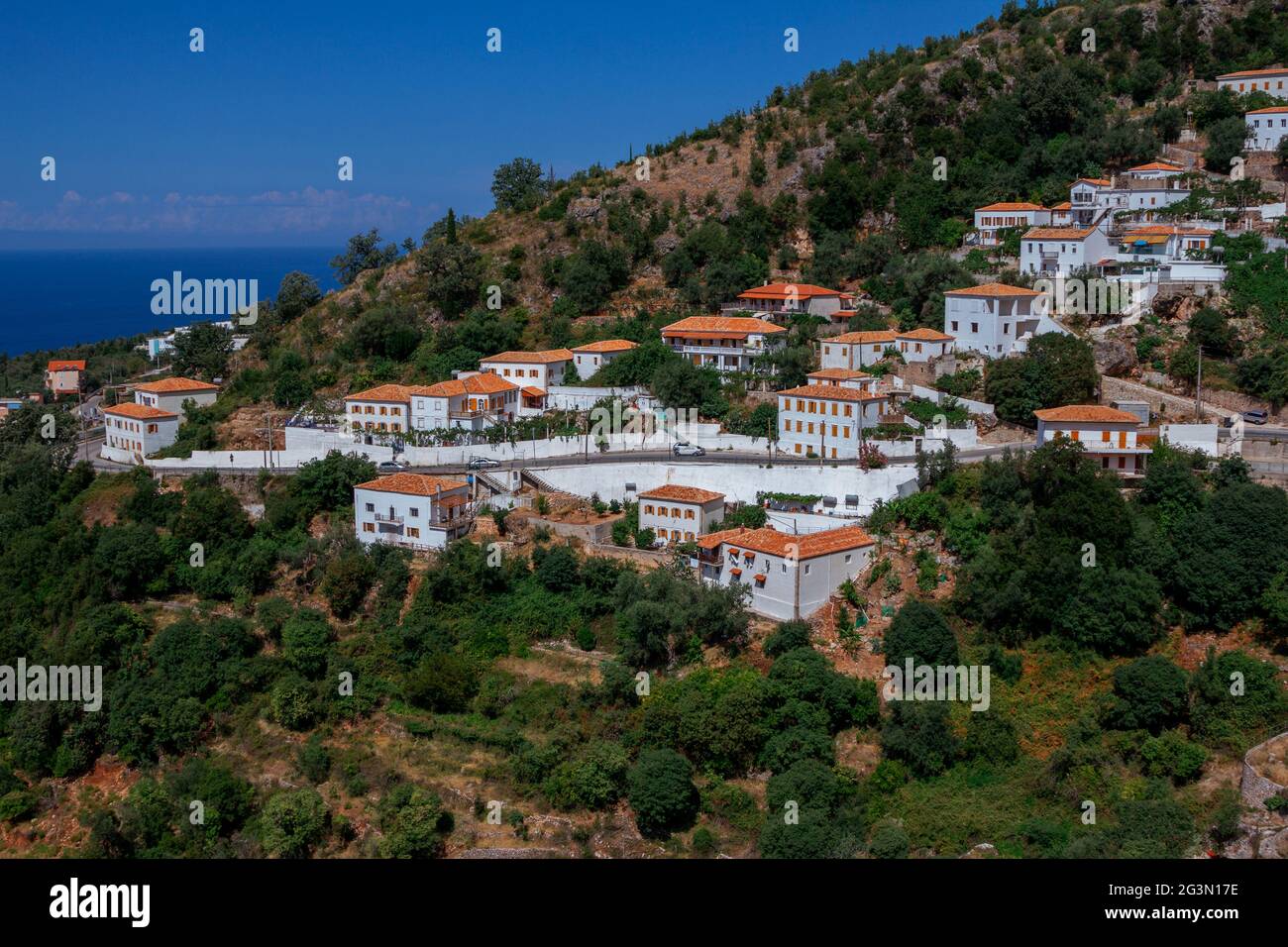 Vuno, Albania - August 7, 2020: view of the village - traditional white houses with orange roofs and wooden shutters on windows - on the mountain hill Stock Photo