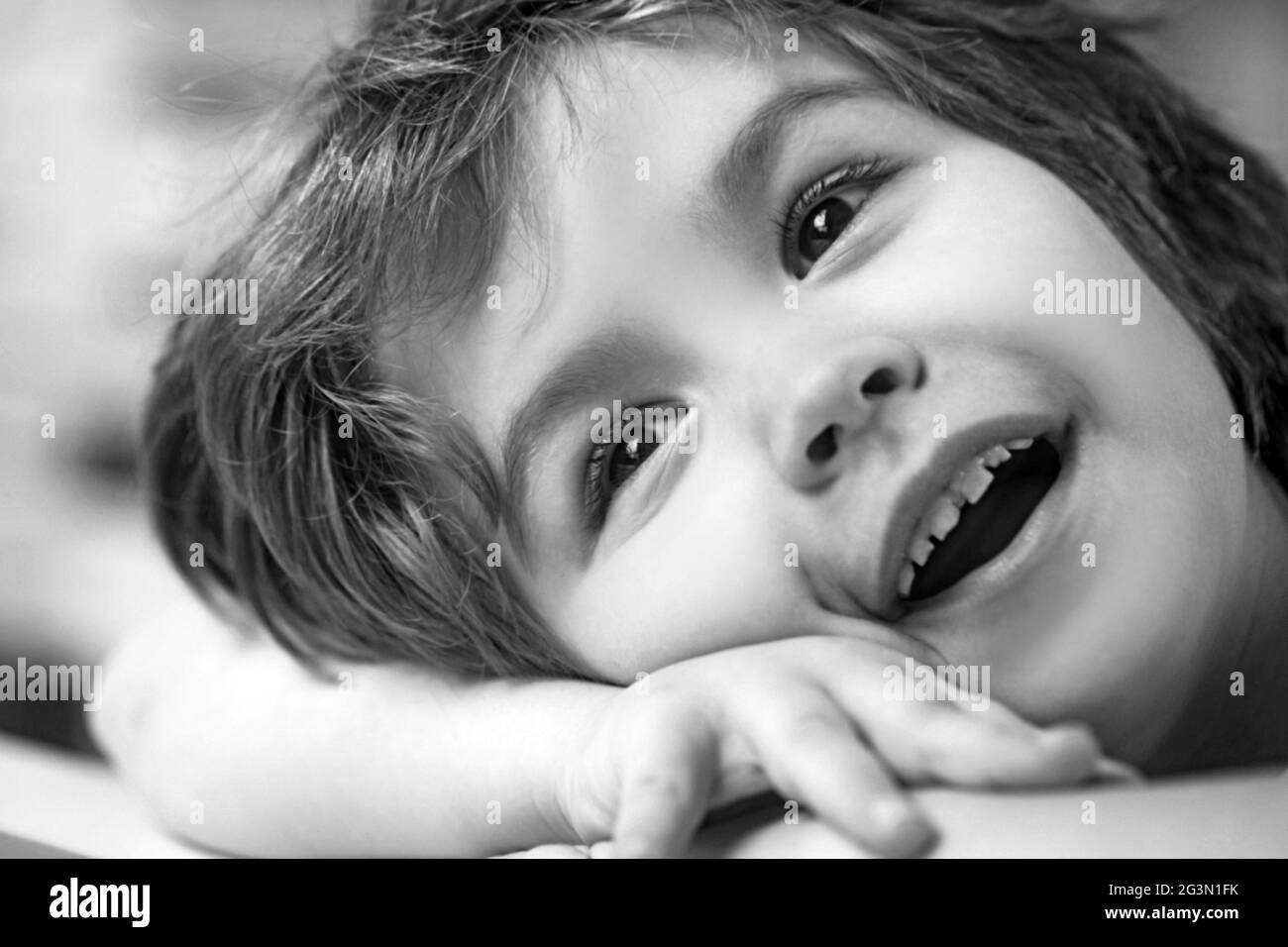 Smiling little boy drawing lying on the desk in the living-room. Stock Photo