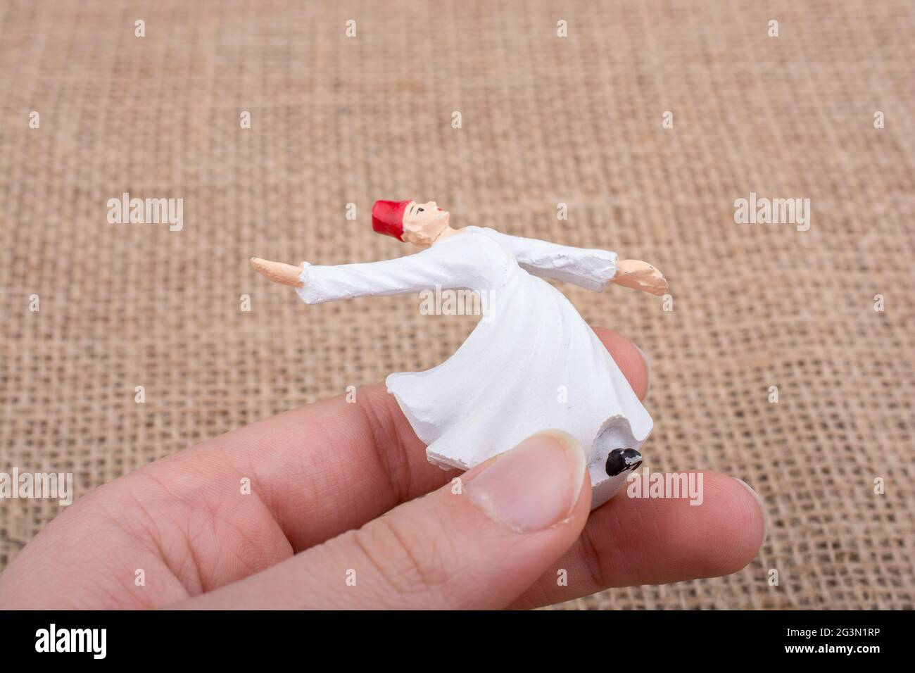 Hand holding a white color Sufi Dervish figurine Stock Photo