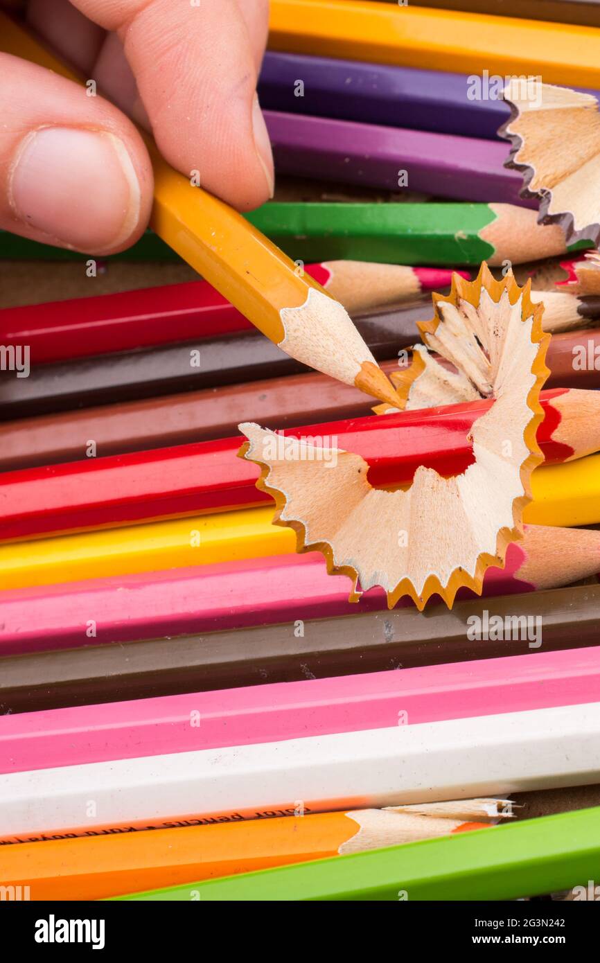Hand holding Color Pencil over a notebook Stock Photo