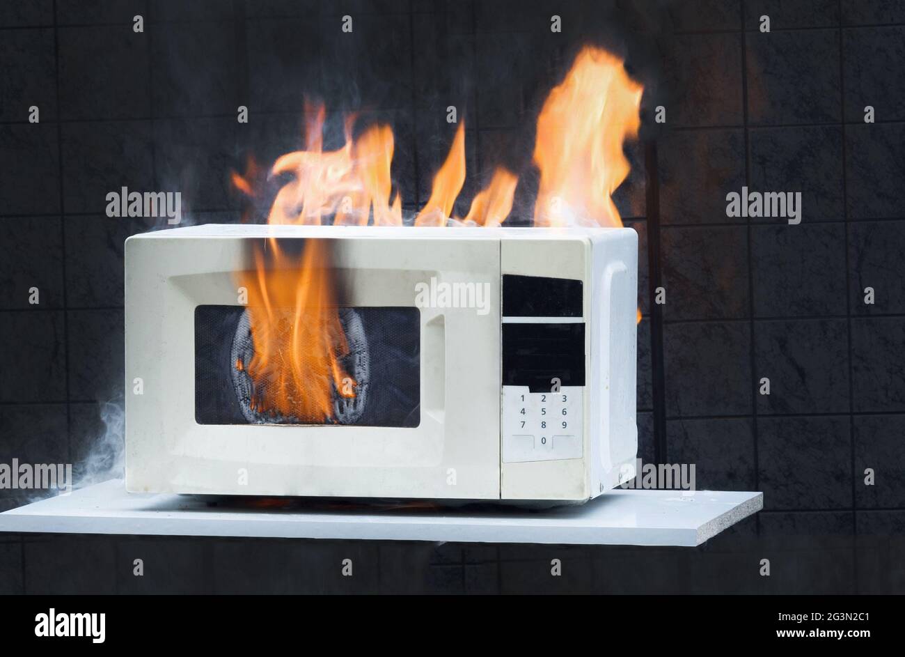 Microwave oven white, in fire front view, electrical appliances caught