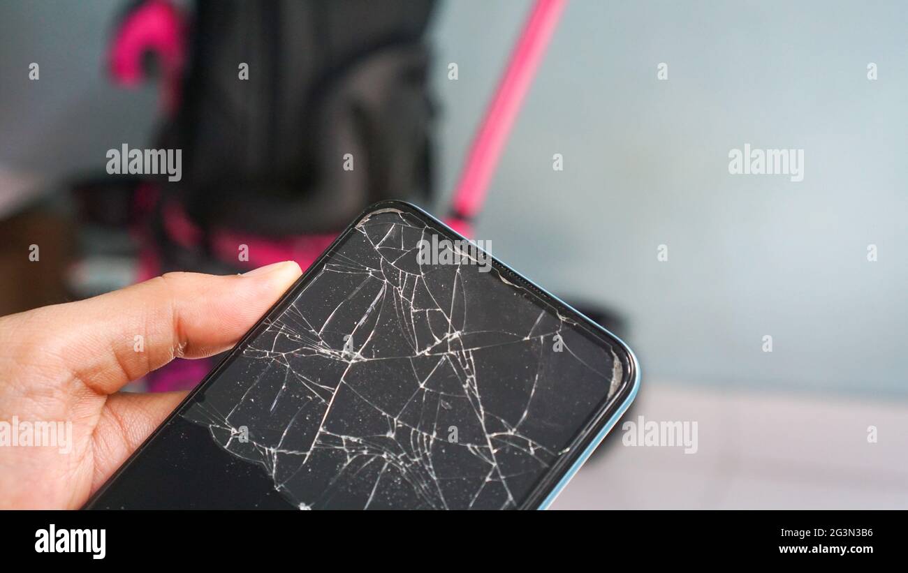 Phone with broken screen cracked, with abstract background close up Stock Photo