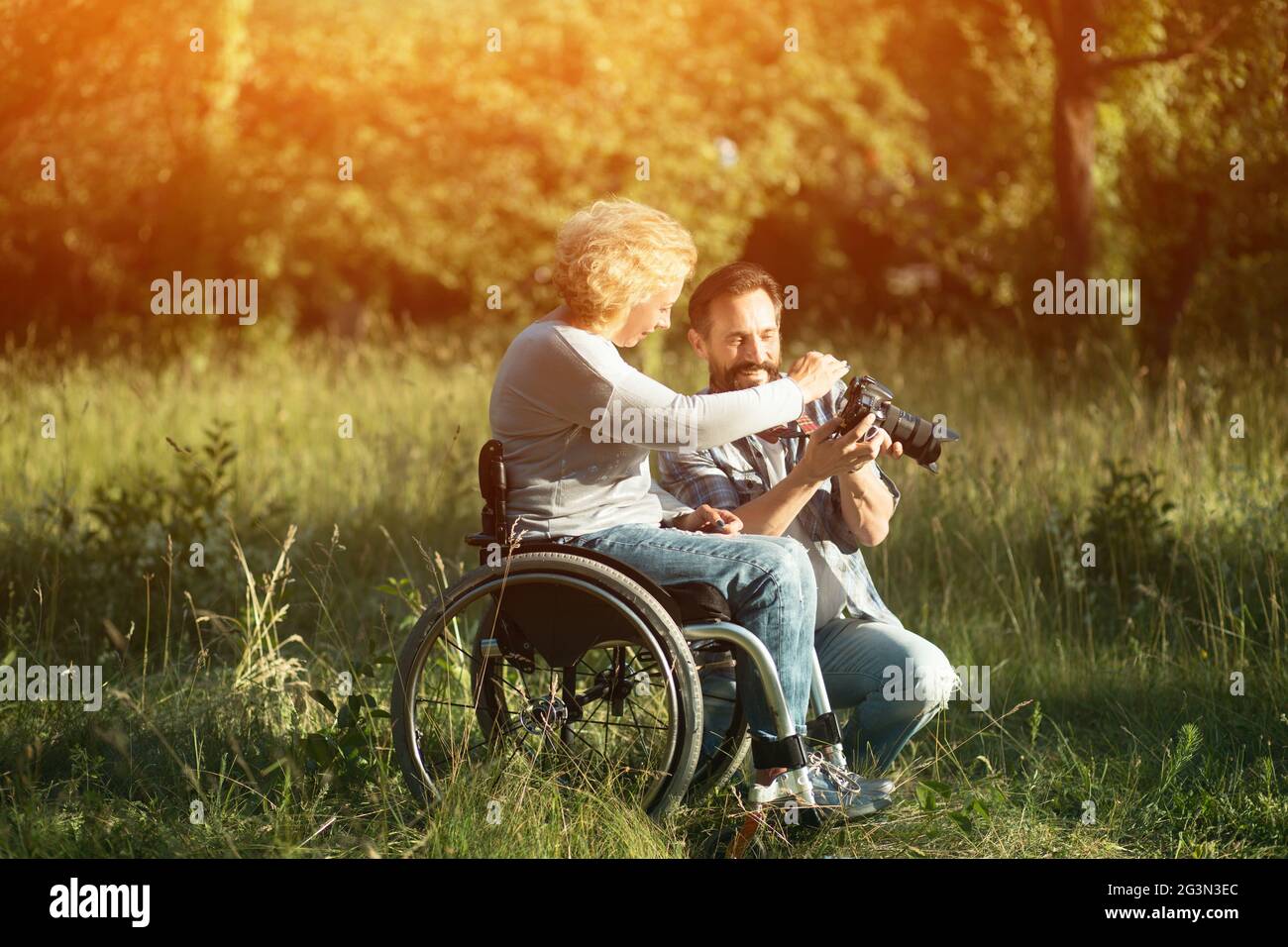 Disabled woman look on the taken photos on camera. Stock Photo