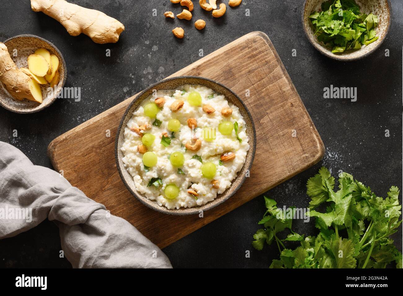 Homemade Curd Rice with pomegranate, cilantro, ginger on a black background. View from above. Indian South ayurvedic cuisine. Stock Photo