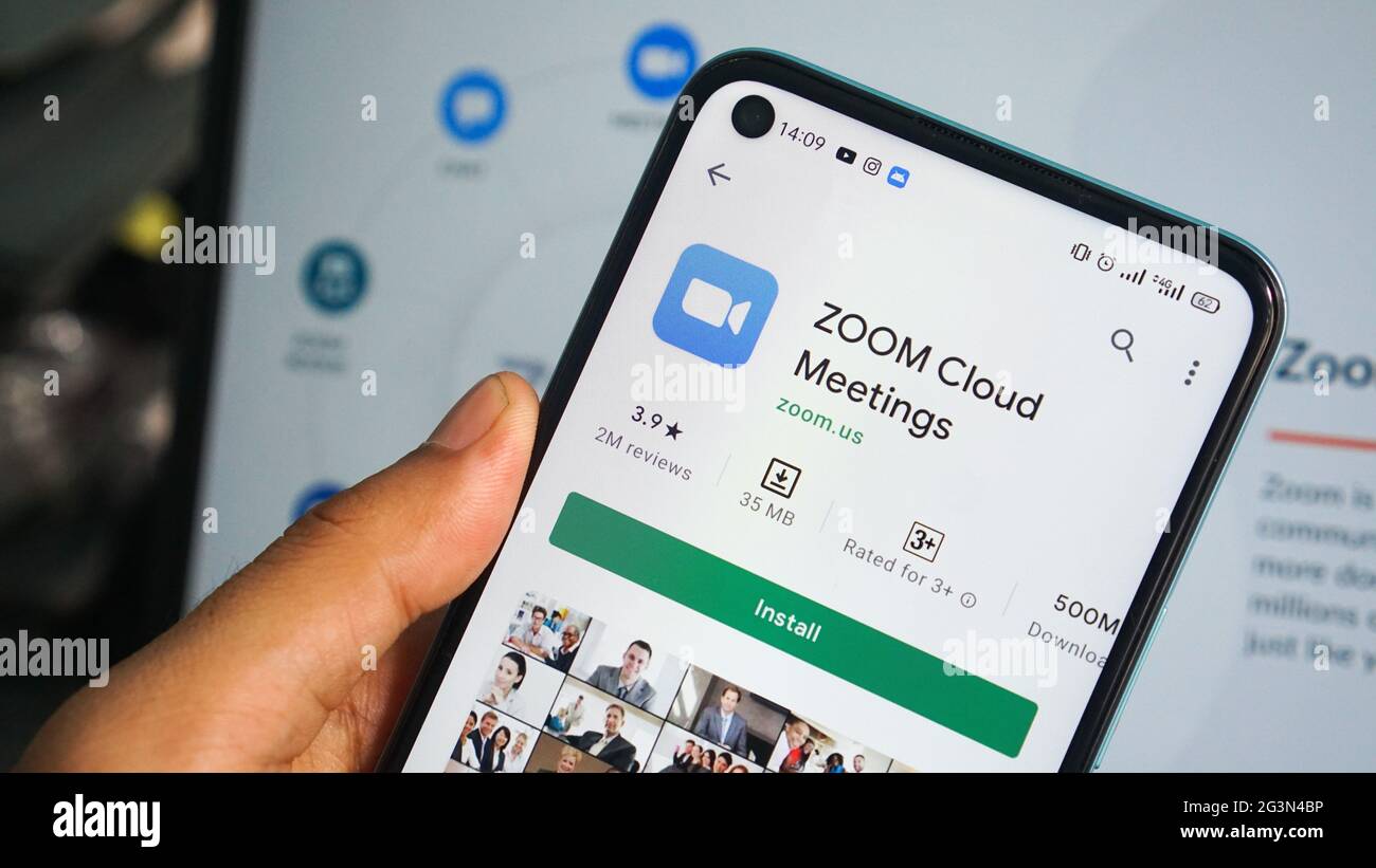 Zoom app display on smartphone, man's hand holding mobile phone