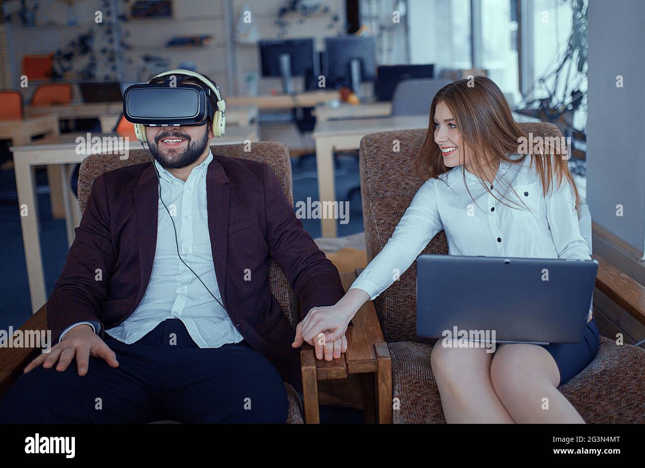 Adult bearded man with virtual reality vr glasses with co-worker at office Stock Photo