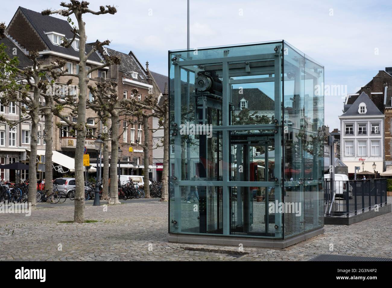 People step into an aboveground glass elevator building that leads to