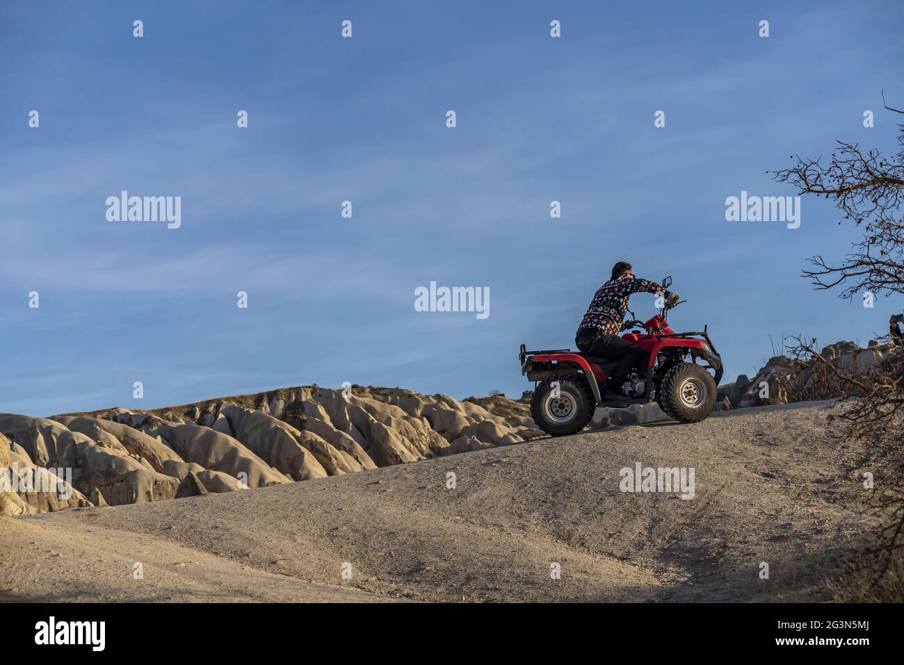 Tourist riding on ATV with the scenery of fairy chimneys in Cappadocia, Turkey Stock Photo