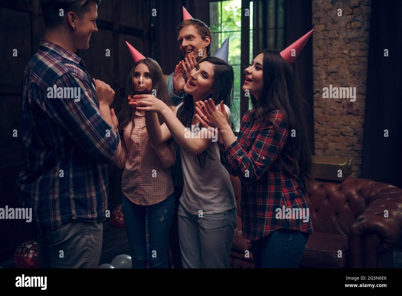 Friends congratulate their friend with birthday cake Stock Photo