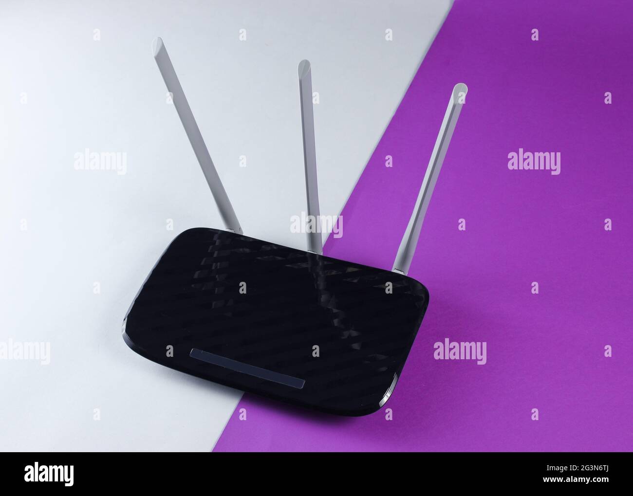 Tried Wi fi router on gray-purple background Stock Photo - Alamy