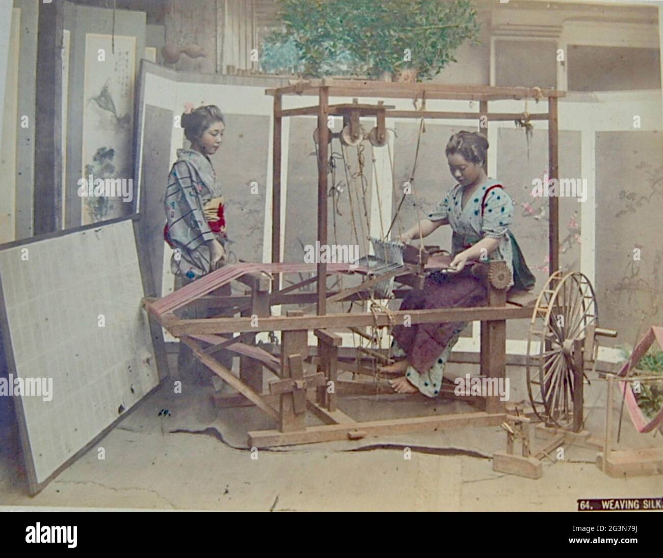 Vintage Kusakabe Kimbei photograph from Old Japan. Two Japanese women weave silk in the traditional way. Stock Photo