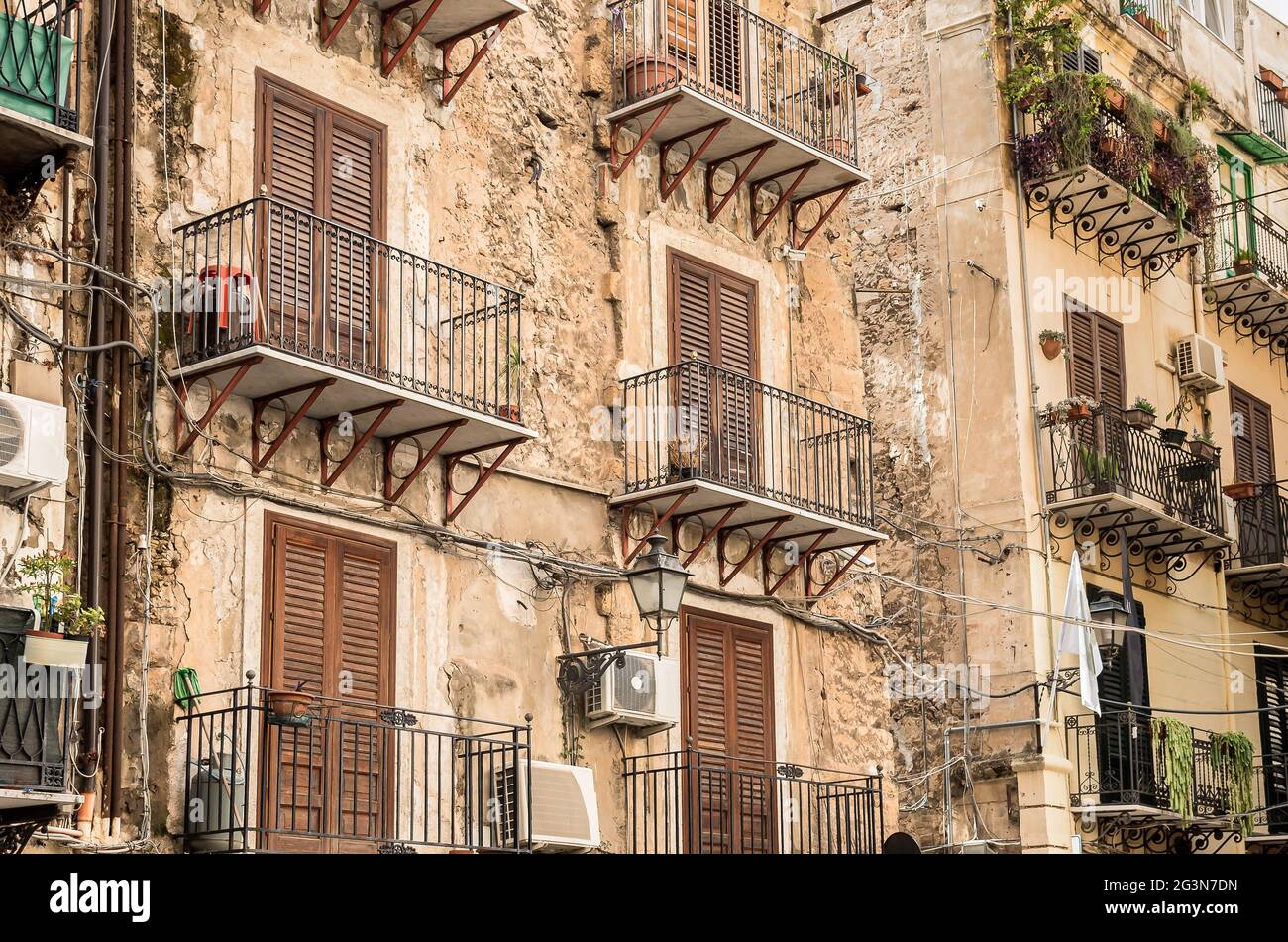 The ruined wall with balconies of an old house in the old city of