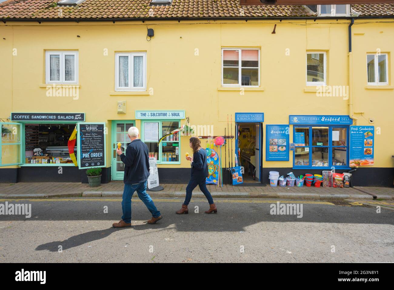 Salcombe shops, view in summer of a couple eating ice creams as they ...