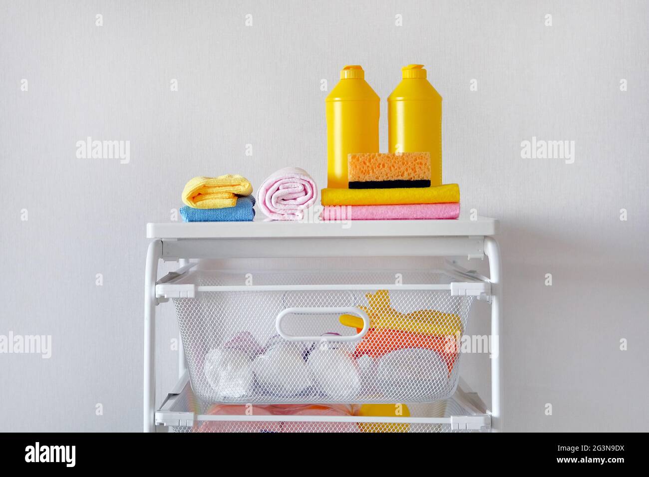 Detergent for cleaning room. Cleaning concept. Yellow plastic bottles with cleaning agent and tools. Regular washing. Stock Photo