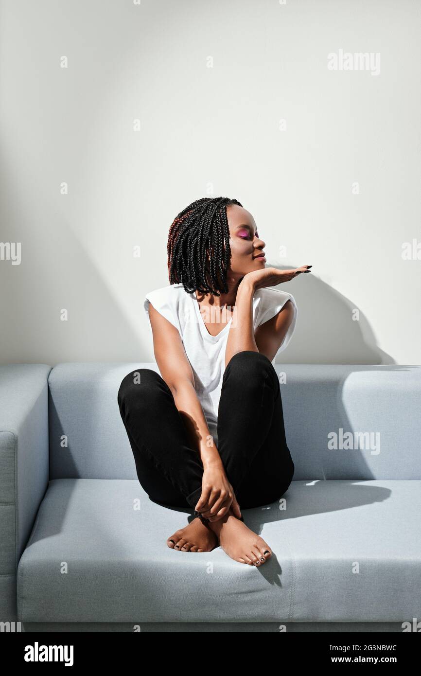 happy african american girl sitting on sofa in the morning Stock Photo ...