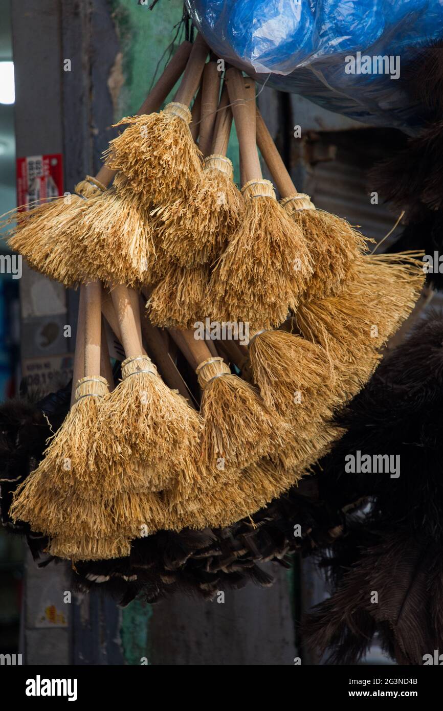 Set of yellow straw broom in bazaar Stock Photo