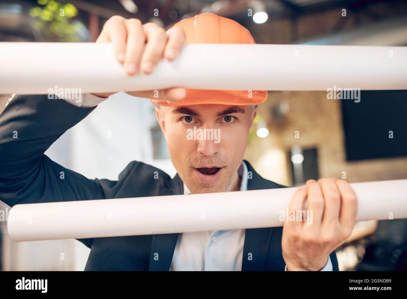 Man in safety helmet with sketches in playful mood Stock Photo