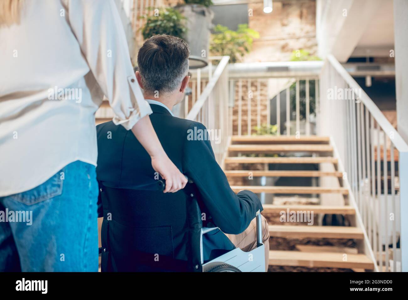 Back view of man in wheelchair and assistant Stock Photo